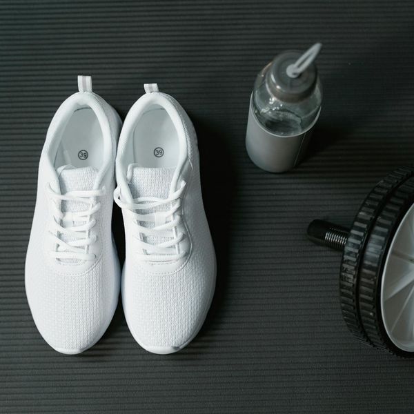 Close up of sports shoes and water bottle on floor.